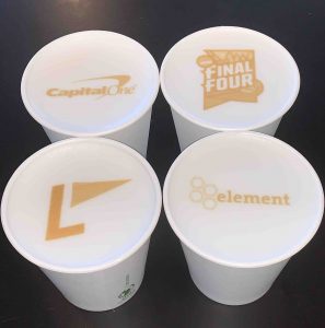Photograph of 4 coffee drinks each with a different logo printed in the foam with the ripples coffee printer